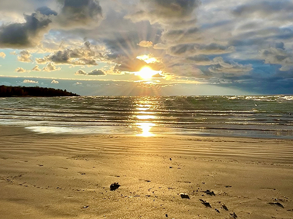 A sunset over water by photographer Caley Patrick Nadjiwon Doran.