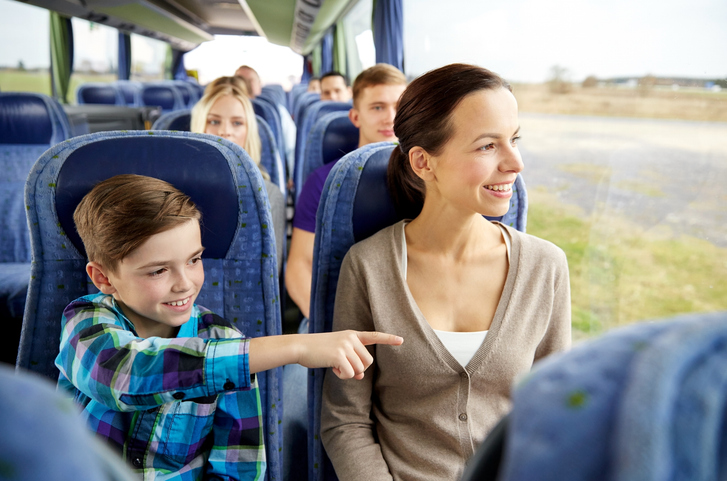 Happy family riding in travel bus 