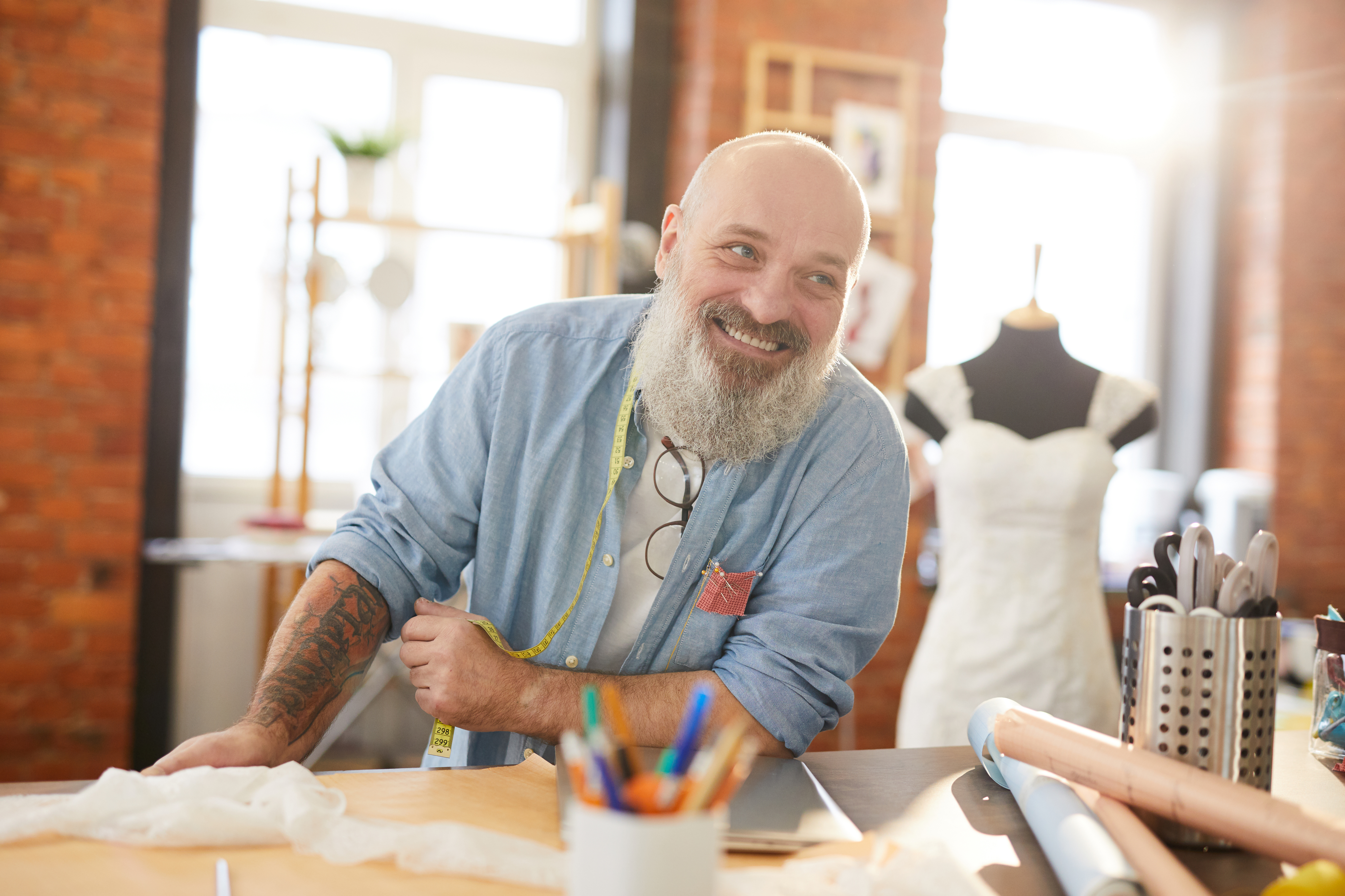 Smiling man chatting with someone at a counter at a store.