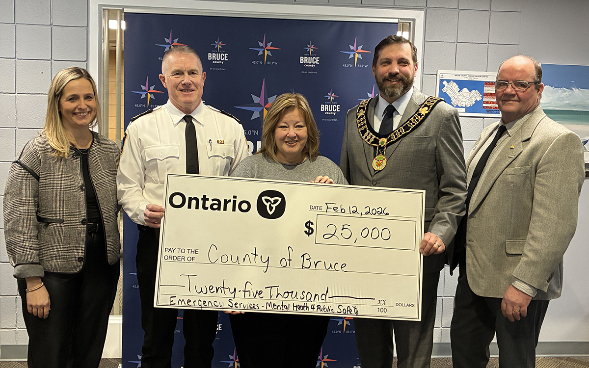A presentation of a novelty cheque for $25,000 of funding for Bruce County’s Emergency Services – Mental Health Supports for Public Safety Personnel. From left – Christine MacDonald, CAO; Steve Schaus, Director/Chief, Paramedic Services; the Honourable Lisa Thompson, MPP for Huron-Bruce; Luke Charbonneau, Warden; and Don Murray, Deputy Warden.