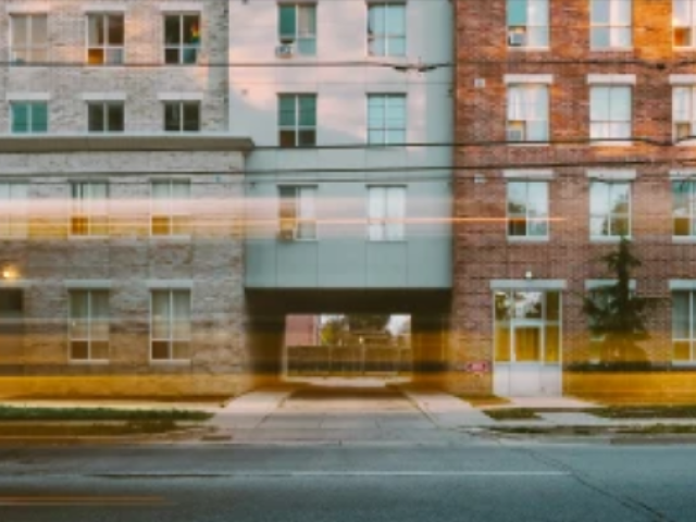 non-profit housing with traffic passing in front