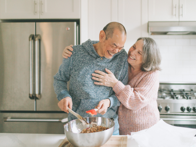 Two people cooking together in kitchen
