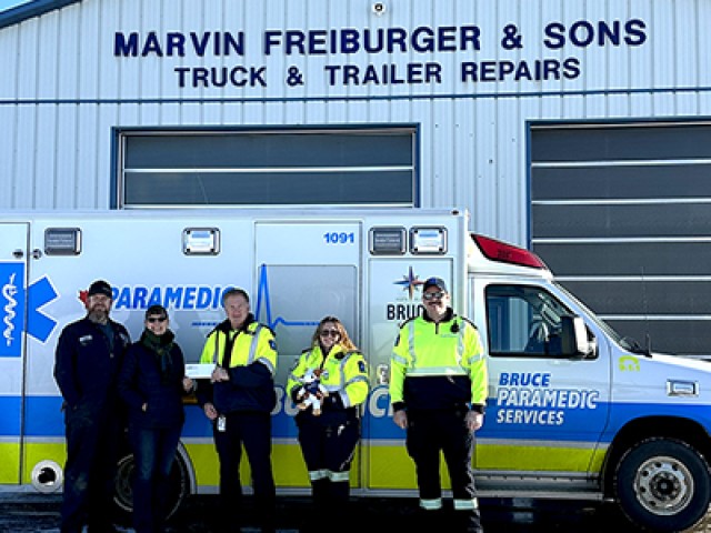 Paramedics in front of Marvin Freiburger & Sons Shop accepting donation