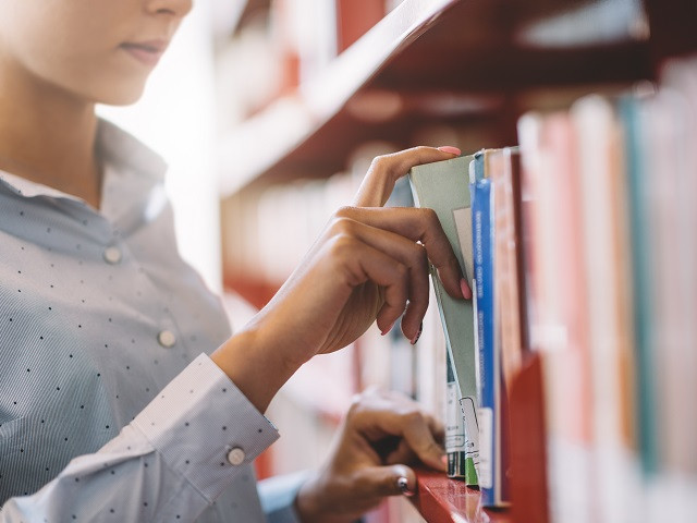 a person taking a book off a shelf