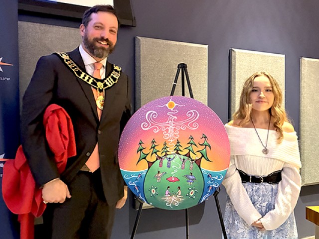 o	Bruce County Warden Luke Charbonneau (left) unveils Aki Ogichidaa with artist Kennedy Cameron-Nashkewa.