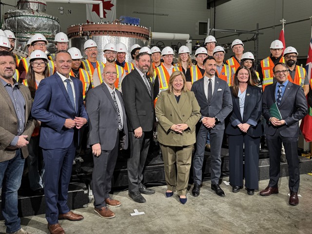 A group of people gather for a photo after a provincial announcement about advancing Canada's first large-scale nuclear build in 30 years.