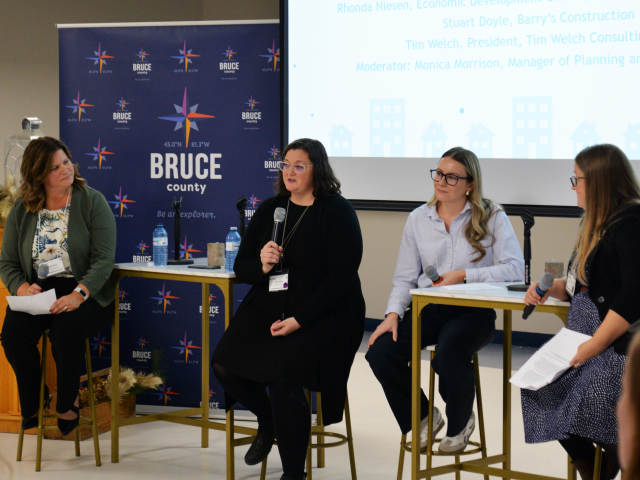 Four women speaking on panel at event