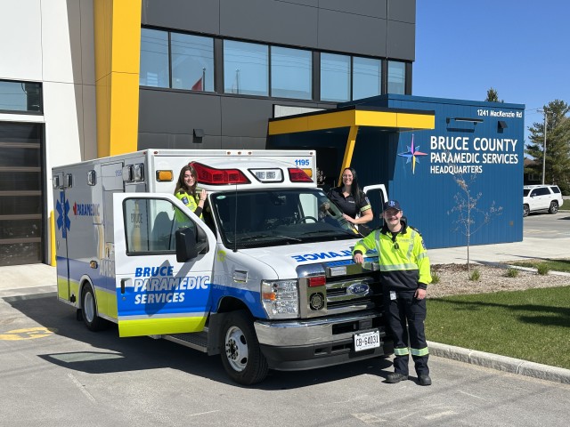Three paramedics standing in front of paramedic truck at Bruce County Paramedic Headquarters