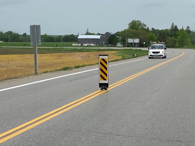 Oncoming vehicle with traffic calming device on road