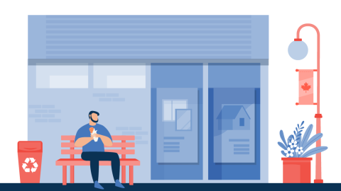 Image of a man on a bench eating a sub outside a business with a recycling bin beside him, new streetscape planters, lighting posts and community banners