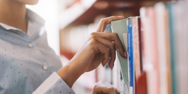 a person taking a book off a shelf