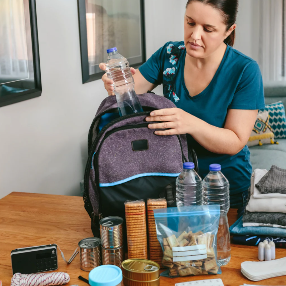 Women packing backpack with emergency supplies